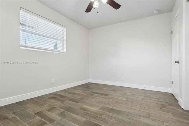 empty room with ceiling fan and a textured ceiling