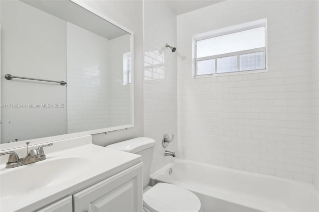 full bathroom featuring toilet, tiled shower / bath, and vanity