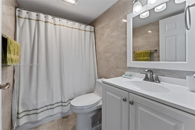 full bathroom with tile patterned flooring, vanity, tile walls, toilet, and shower / bath combo