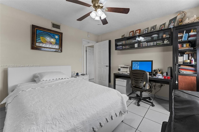 bedroom with light tile patterned flooring, a textured ceiling, and ceiling fan