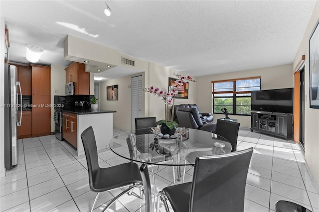 dining space with light tile patterned floors and a textured ceiling