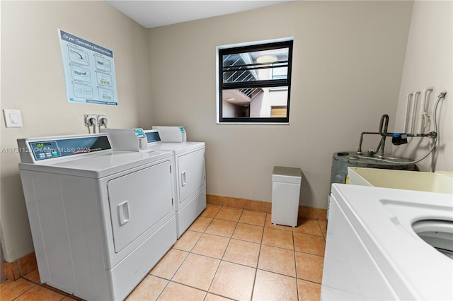 laundry area with washing machine and dryer and light tile patterned floors