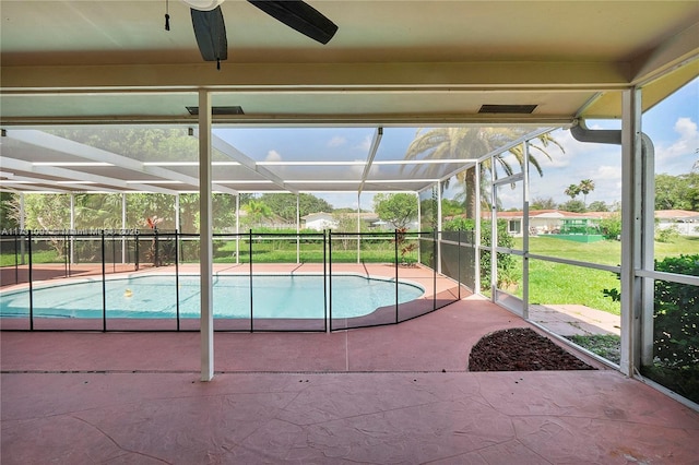 view of swimming pool featuring a fenced in pool, glass enclosure, a patio area, and ceiling fan