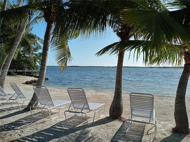 view of patio / terrace featuring a water view and a beach view