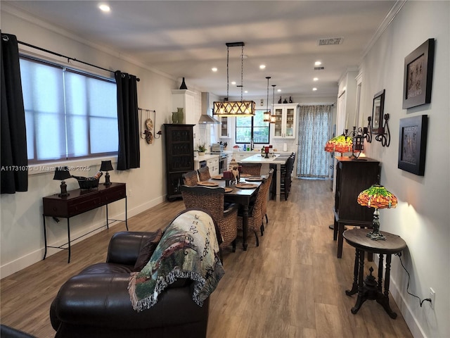 living room featuring wood-type flooring and crown molding