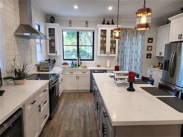 kitchen with stainless steel refrigerator with ice dispenser, wine cooler, black electric range, wall chimney exhaust hood, and decorative light fixtures