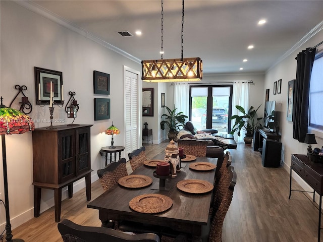 dining room featuring crown molding, french doors, and light wood-type flooring