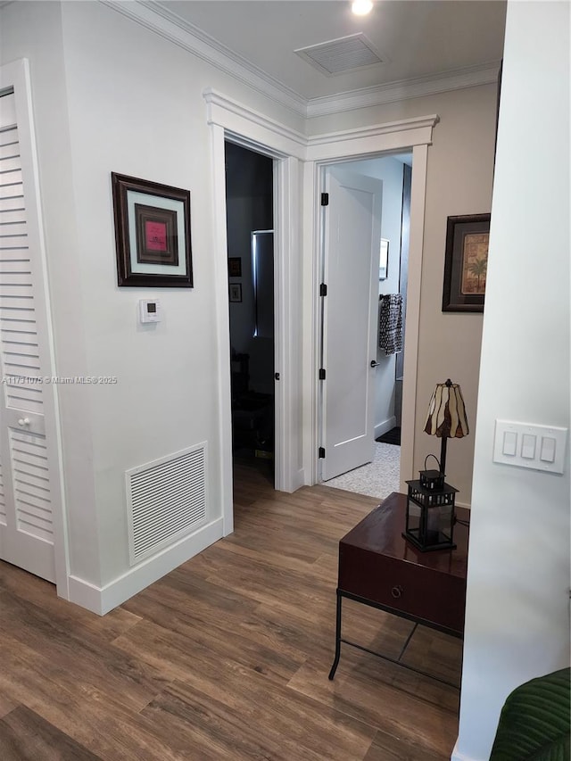 corridor featuring wood-type flooring and crown molding