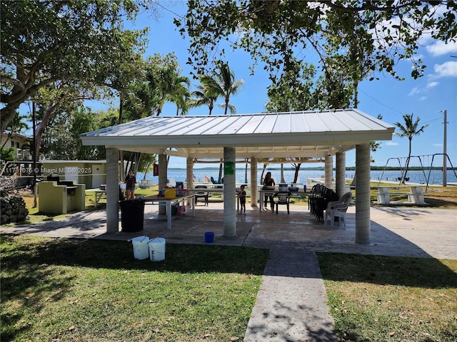 view of community featuring a water view, a gazebo, and a lawn