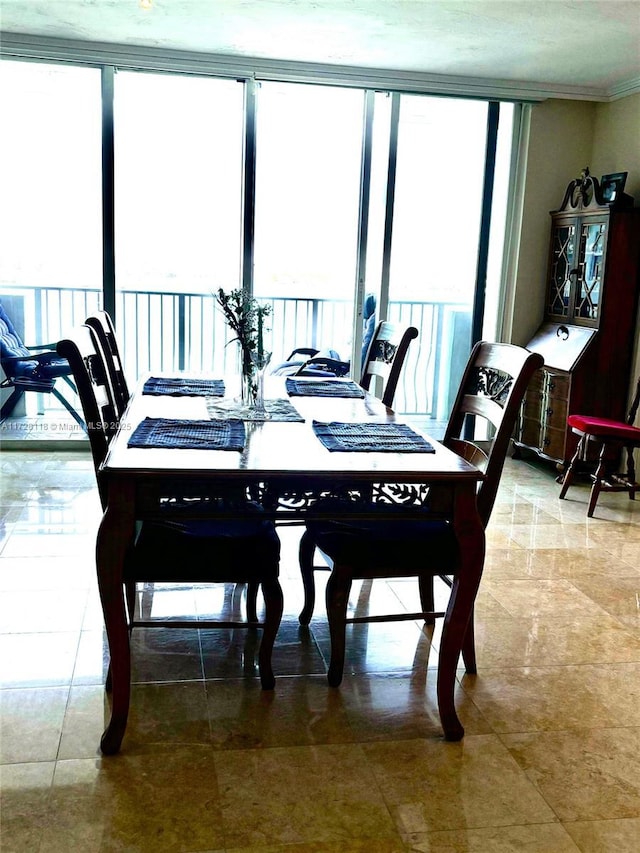 dining space featuring ornamental molding and a wall of windows