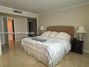 bedroom featuring crown molding and light tile patterned flooring