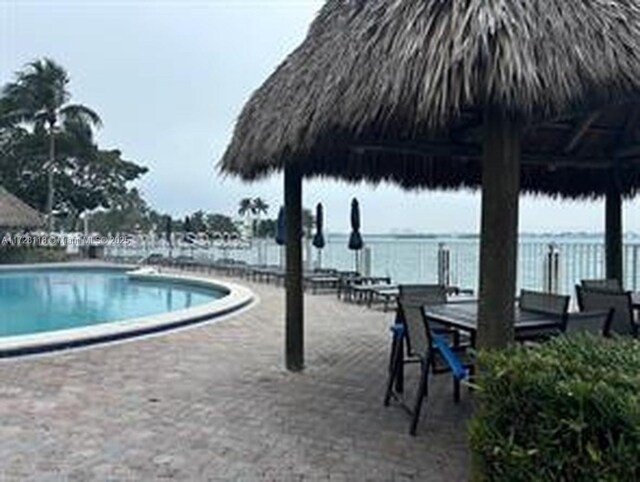 view of swimming pool with a water view, a gazebo, and a patio area