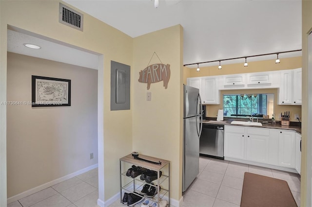 kitchen featuring light tile patterned flooring, electric panel, white cabinetry, and appliances with stainless steel finishes