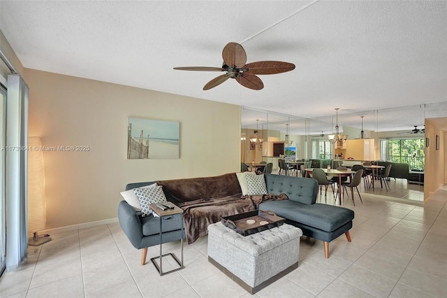 tiled living room featuring ceiling fan with notable chandelier and a textured ceiling