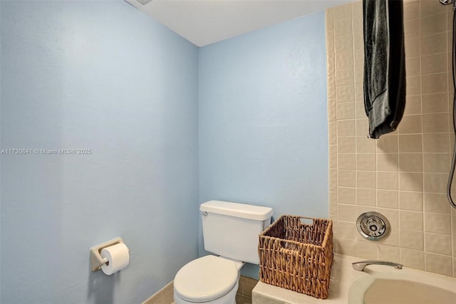 bathroom featuring tiled shower / bath combo and toilet