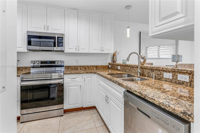 kitchen featuring sink, decorative light fixtures, white cabinetry, dark stone countertops, and stainless steel appliances