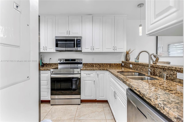 kitchen with sink, white cabinets, decorative light fixtures, and appliances with stainless steel finishes