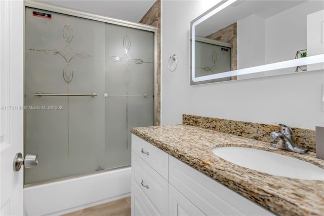 bathroom with bath / shower combo with glass door and vanity