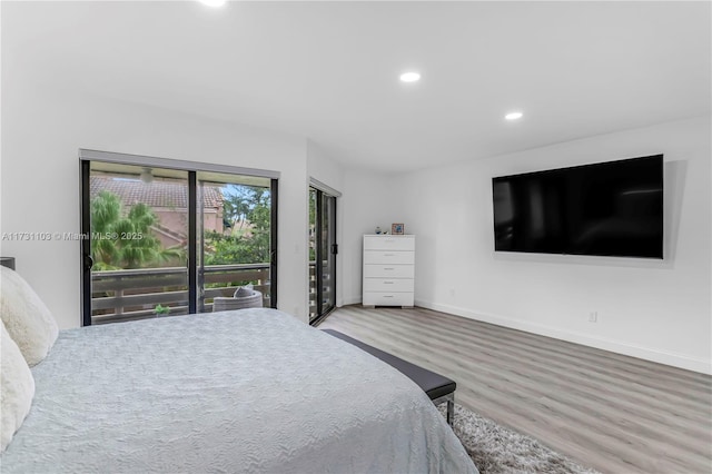 bedroom with hardwood / wood-style floors and access to outside