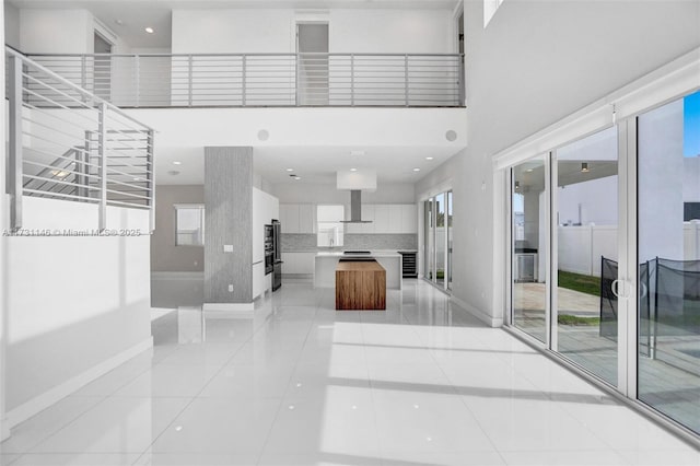 interior space featuring a high ceiling and light tile patterned flooring