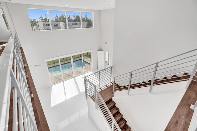 staircase with tile patterned flooring, a wealth of natural light, and a high ceiling