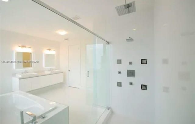 bathroom featuring a shower with door and vanity