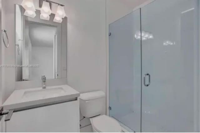 bathroom featuring vanity, toilet, and walk in shower