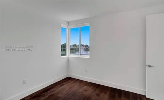 spare room with dark wood-type flooring