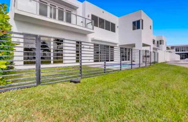 rear view of property featuring a lawn