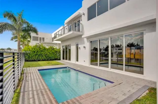 rear view of house featuring a fenced in pool