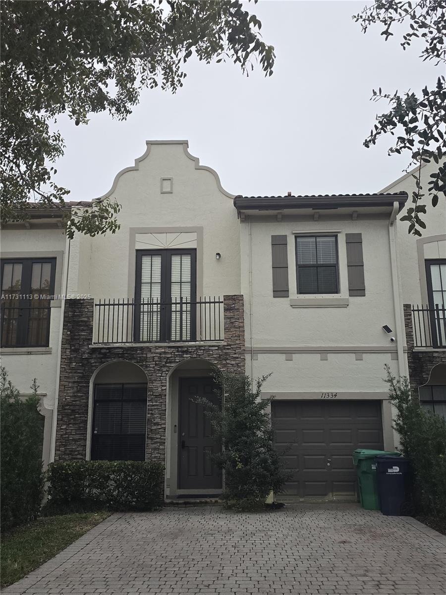 view of front of house featuring a garage and a balcony