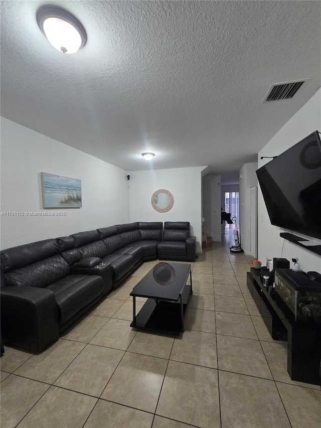 tiled living room featuring a textured ceiling