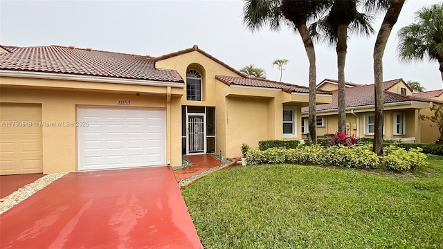 mediterranean / spanish home with a garage and a front lawn