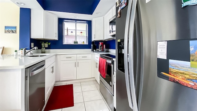 kitchen with sink, white cabinets, light tile patterned floors, and appliances with stainless steel finishes