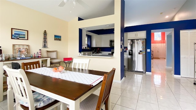 tiled dining area with ceiling fan and lofted ceiling