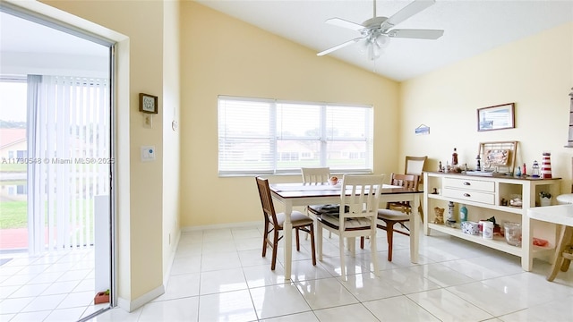 tiled dining space featuring ceiling fan and vaulted ceiling