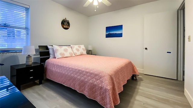 bedroom with light wood-type flooring, multiple windows, and ceiling fan