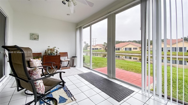 sunroom featuring a water view and ceiling fan