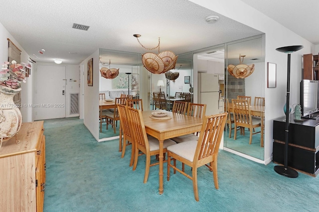 dining space featuring a textured ceiling and carpet