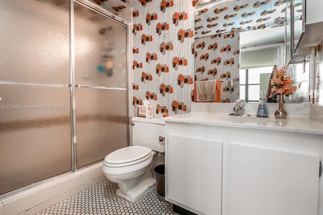 bathroom with tile patterned floors, an enclosed shower, vanity, and toilet