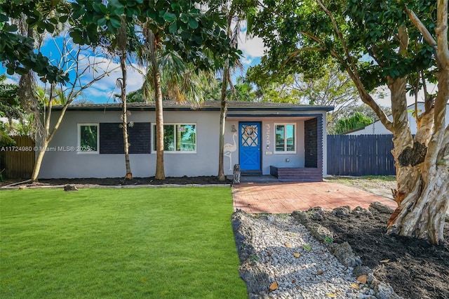 ranch-style home featuring a front yard and a patio