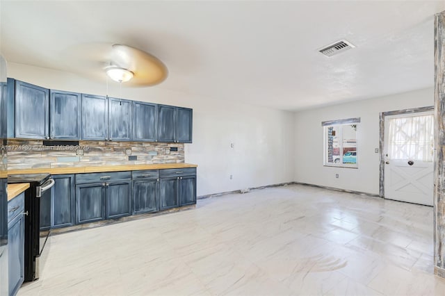 kitchen featuring electric stove, backsplash, butcher block counters, and blue cabinets