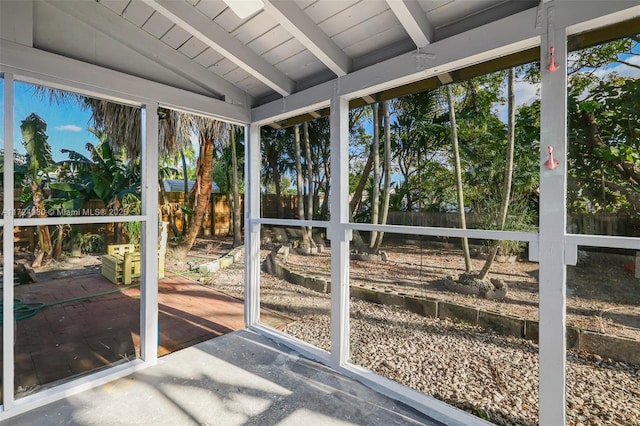 unfurnished sunroom with wood ceiling, a wealth of natural light, and vaulted ceiling with beams