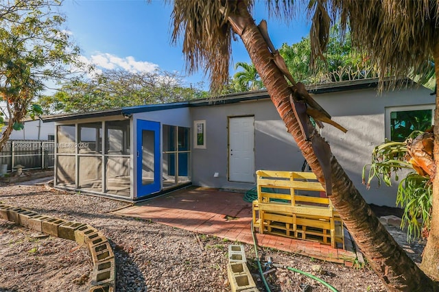 rear view of house with a sunroom and a patio