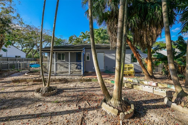 rear view of house featuring a sunroom