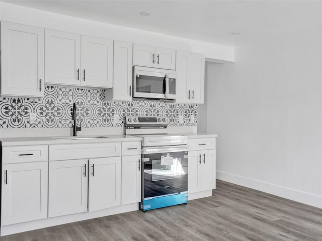 kitchen with sink, stainless steel appliances, light hardwood / wood-style floors, and white cabinets