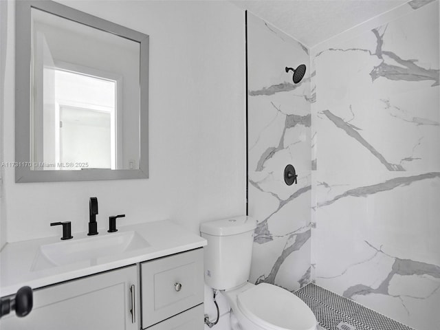 bathroom featuring vanity, toilet, and a shower