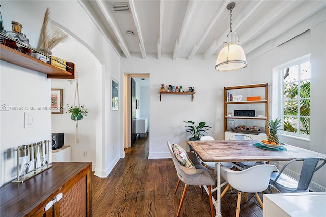 dining area featuring dark wood-type flooring and beamed ceiling