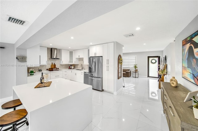 7900 SW 97th Ave, Miami, FL 33173 - kitchen with stainless steel appliances, wall chimney exhaust hood, light marble finish flooring, decorative backsplash, and a kitchen breakfast bar