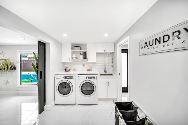 washroom featuring washing machine and clothes dryer, recessed lighting, cabinet space, a sink, and marble finish floor